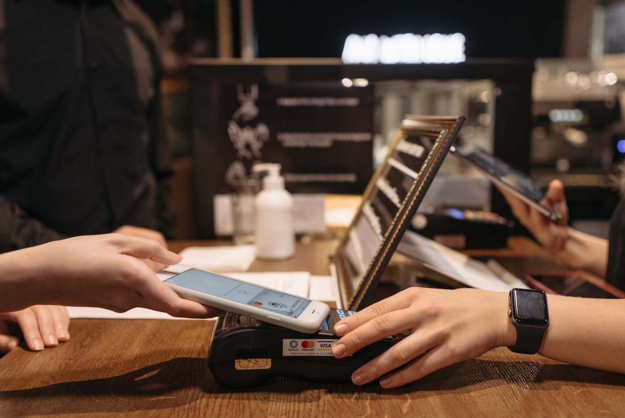 menu-06 Hands using mobile for contactless payment at café terminal.