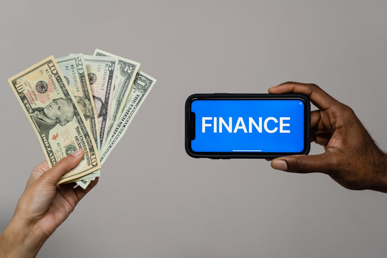menu-03 Image depicting currency and finance concept with hands holding cash and a smartphone.